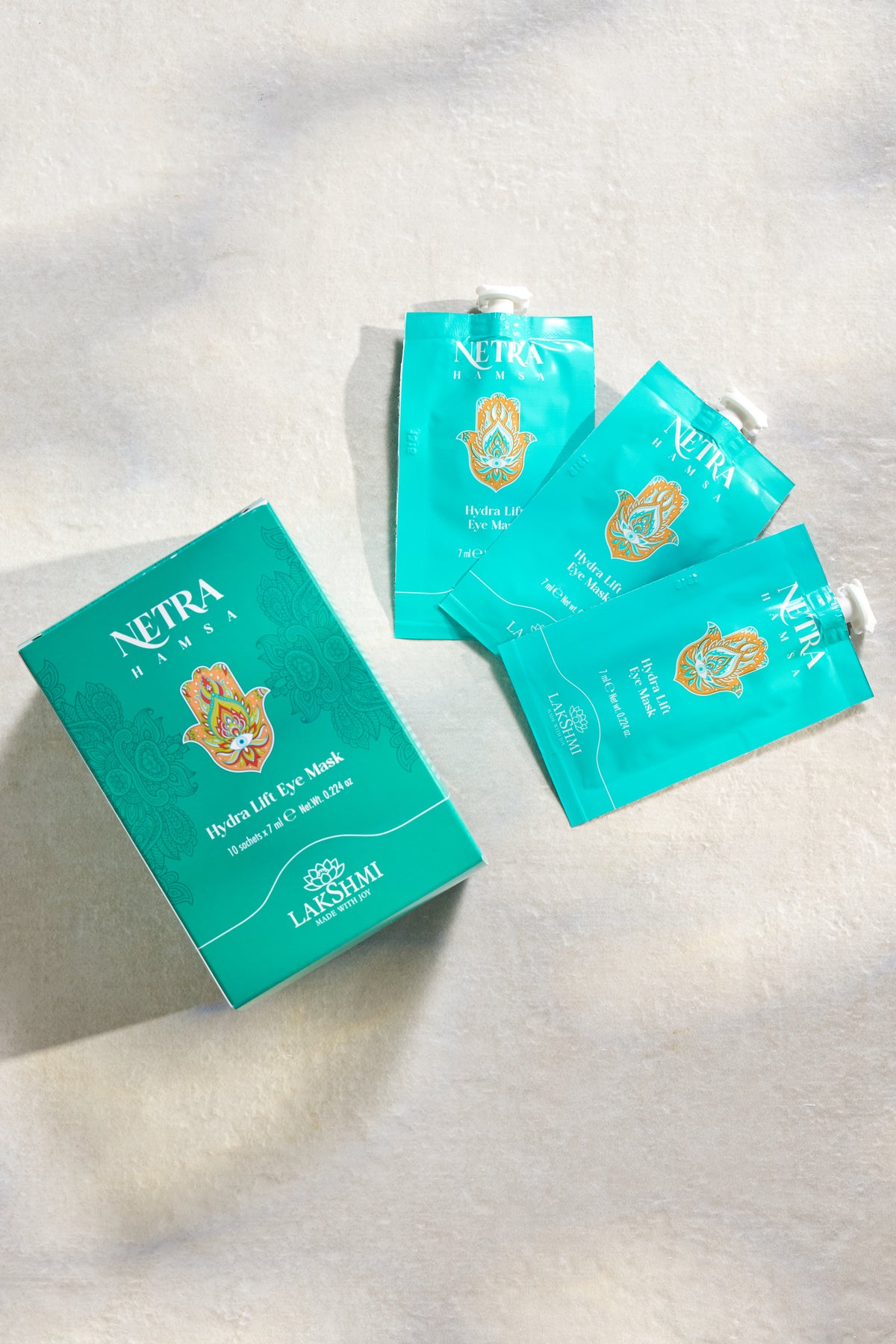 Three Lakshmi NETRA Hydra Lift Eye Mask sachets on a pale surface