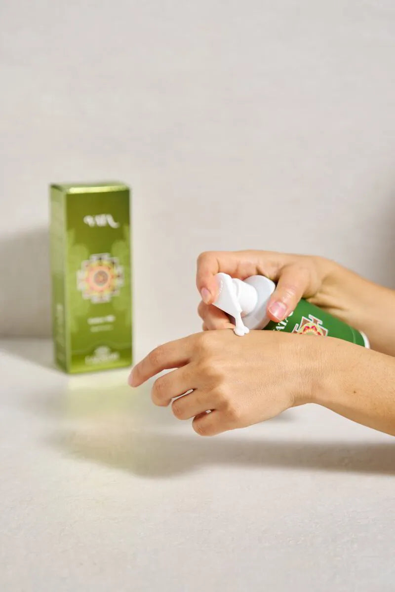 Hand dispensing Lakshmi VATA Radiant Milk beside its green box