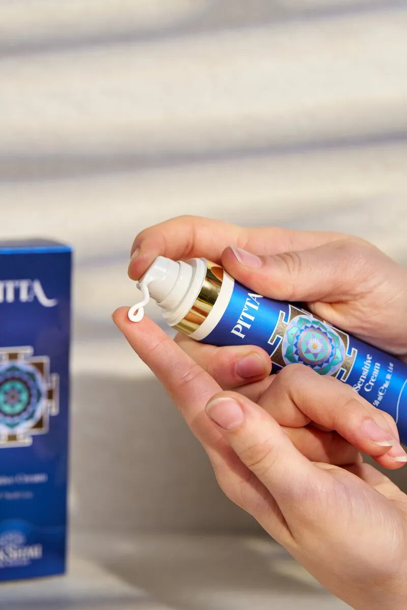 Hands dispensing PITTA Sensitive Cream from the pump bottle